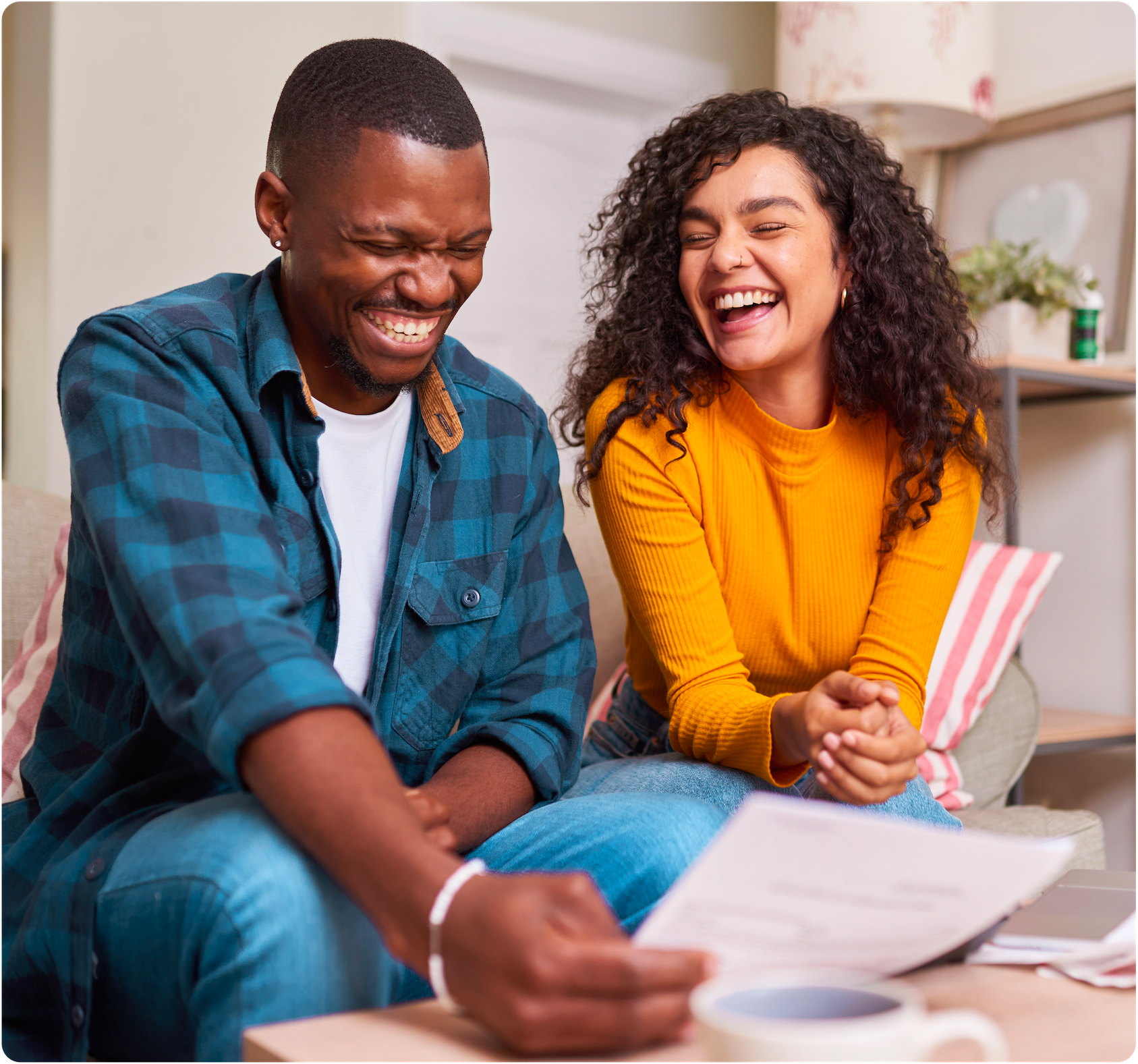 Man and woman laughing, looking at a document