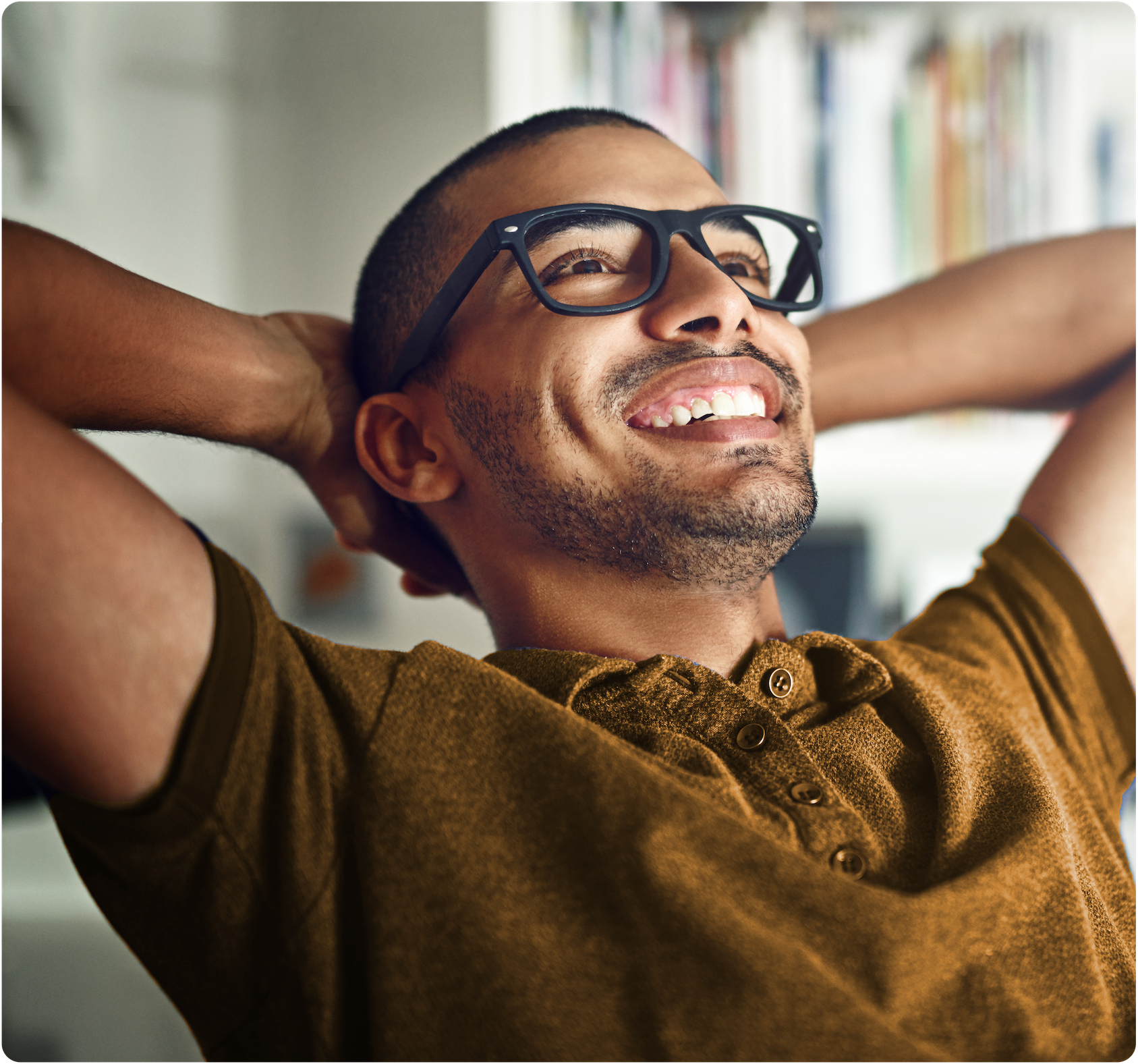 Man sitting back with arms behind head, smiling