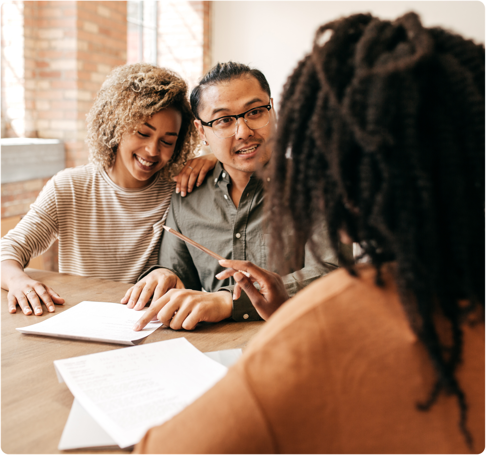 Husband and wife discussing a document with another woman