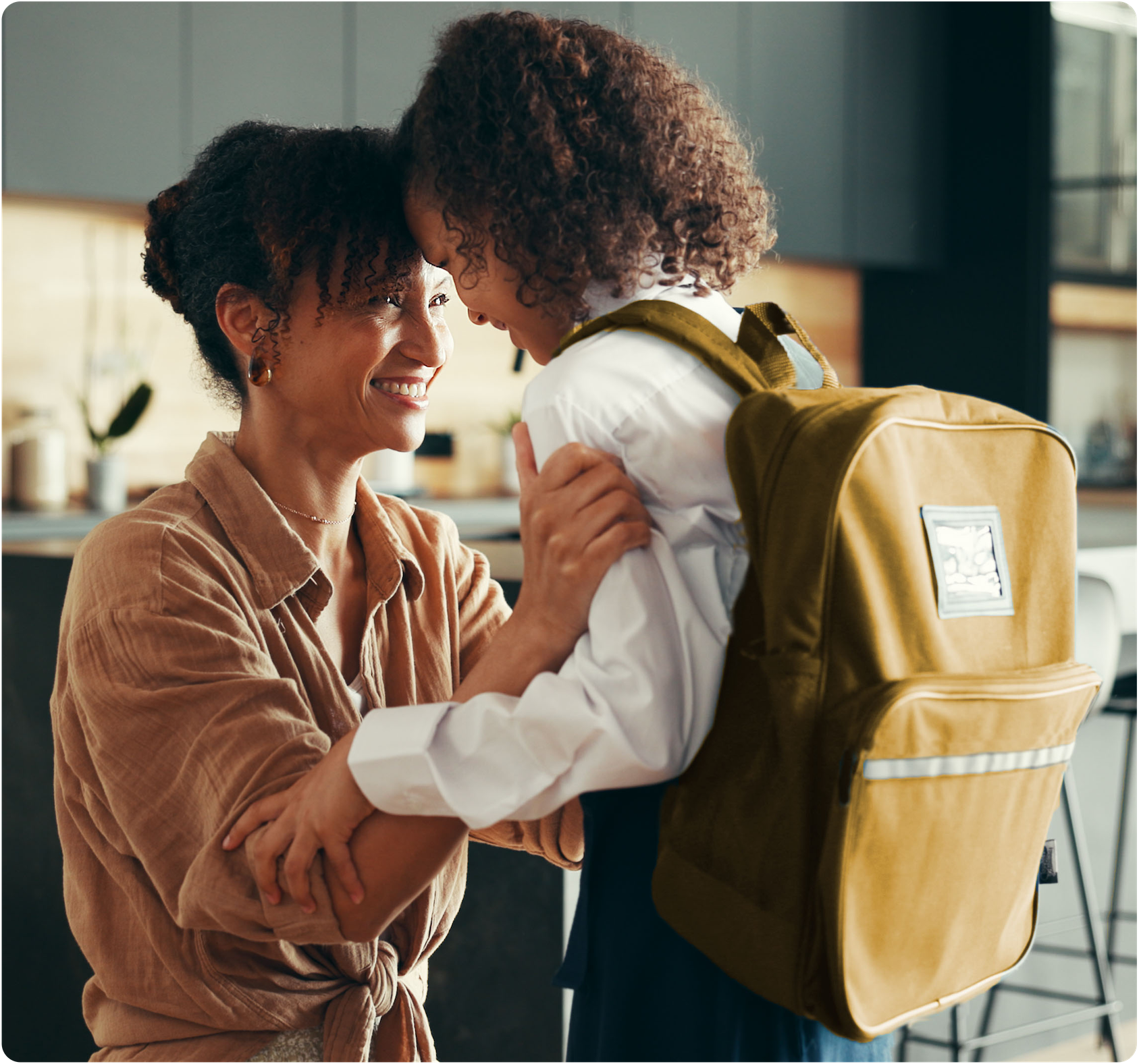 Mother holding her child with school backpack